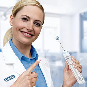 Oral-B iO Zahnbürste, präsentiert von einer Zahnärztin, die auf die innovative runde Bürstenkopf-Technologie hinweist.