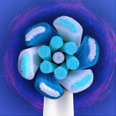 A close-up view of a circular electric toothbrush head with white, light blue, and dark blue bristles in a patterned arrangement.