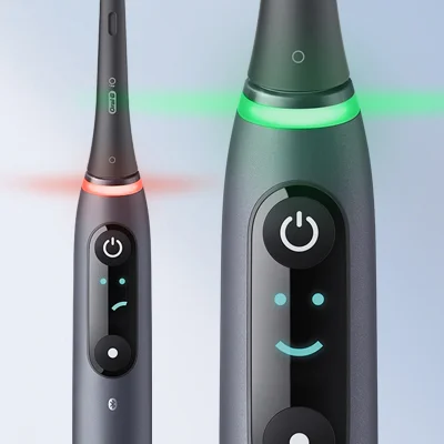 Oral-B iO elektrische Zahnbürste, die den Andrucksensor mit rotem und grünem Licht sowie ein Smiley-Display zeigt.
