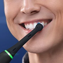 Oral-B Zahnbürste in Schwarz beim Zähneputzen, um saubere und gesunde Zähne zu zeigen.
