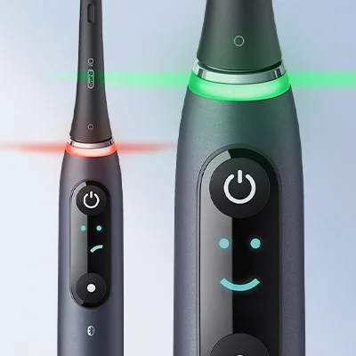 Oral-B iO elektrische Zahnbürste mit interaktivem Display, das ein Smiley-Gesicht für positives Feedback und einen roten Warnhinweis für zu starken Druck zeigt.