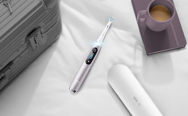 Oral-B iO elektrische Zahnbürste in Reisestimmung, mit Reiseetui und Koffer für unterwegs.