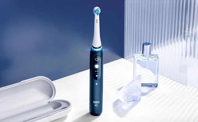 Oral-B iO elektrische Zahnbürste in Dunkelblau, mit Reiseetui und leuchtendem Bürstenkopf.