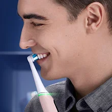 Oral-B Zahnbürste im Einsatz, ein lächelnder Mann putzt sich die Zähne und demonstriert die Anwendung.