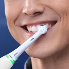 Oral-B Zahnbürste im Einsatz, die Zähne eines lächelnden Mannes reinigend.