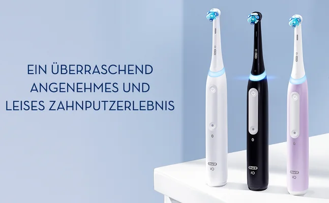 Three electric toothbrushes in pink, black, and white stand on a white surface with the text EIN ÜBERRASCHEND ANGENEHMES UND LEISES ZAHNPUTZERLEBNIS.