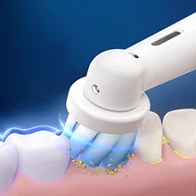 Oral-B Zahnbürstenkopf in Aktion, der Plaque von einem Zahn entfernt und für saubere Zähne sorgt.