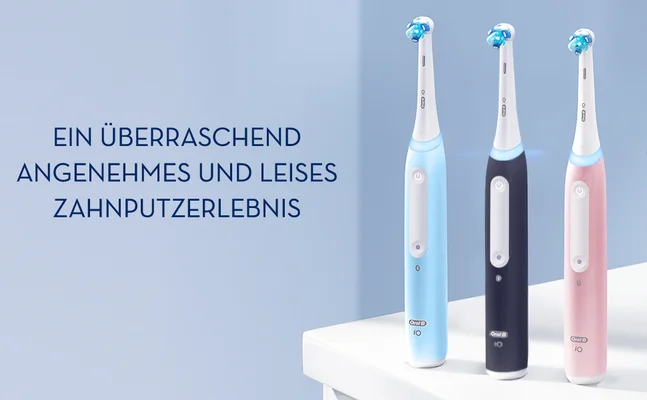 Three electric toothbrushes in pink, black, and white stand on a white surface with the text EIN ÜBERRASCHEND ANGENEHMES UND LEISES ZAHNPUTZERLEBNIS.