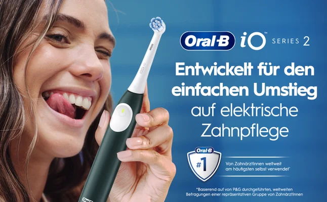 A smiling woman with long hair playfully sticking out her tongue holds an electric toothbrush against a blue background, with text that reads Oral-B iO Series 2 Entwickelt für den einfachen Umstieg auf elektrische Zahnpflege Oral-B #1 Von ZahnärztInnen weltweit am häufigsten selbst verwendet *Basierend auf von P&G durchgeführten, weltweiten Befragungen einer repräsentativen Gruppe von ZahnärztInnen.