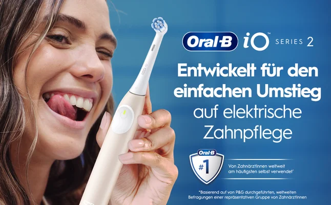 Lächelnde Frau mit Elektrischer Zahnbürste in der Hand