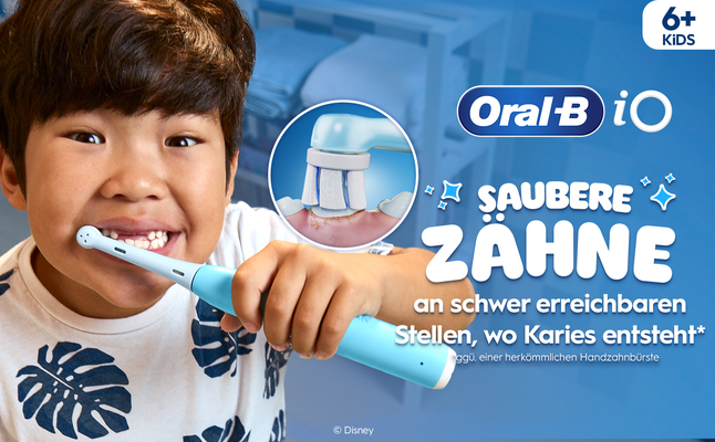 Ein lächelndes Kind putzt sich die Zähne mit der Oral-B iO Kids 6+, mit einer Nahaufnahme der Bewegung der elektrischen Zahnbürste auf seinen Zähnen.