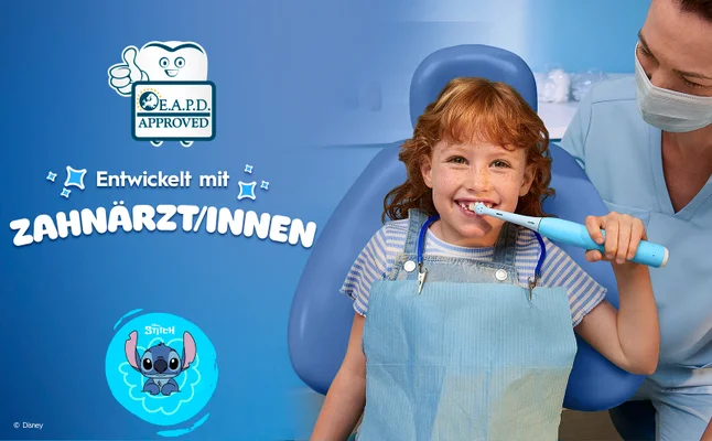Ein Zahnarzt und ein Kind im Zahnarztstuhl putzen mit iO Kids 6+, entwickelt von Zahnärzten.