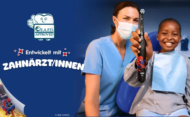 Ein Zahnarzt und ein Kind im Zahnarztstuhl putzen mit iO Kids 6+, entwickelt von Zahnärzten.