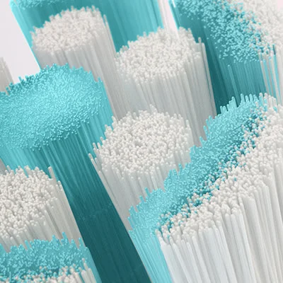 Close-up view of toothbrush bristles, some white and some light blue.