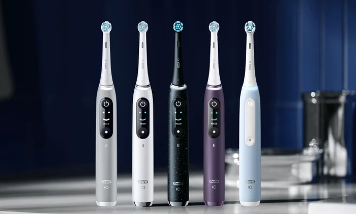 Fünf Oral-B iO Zahnbürsten in verschiedenen Farben mit beleuchtetem Display auf einem Badezimmertisch