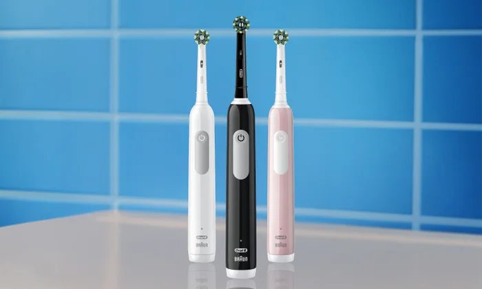 Drei Oral-B Pro Zahnbürsten in Weiß, Schwarz und Rosa vor blauem Hintergrund