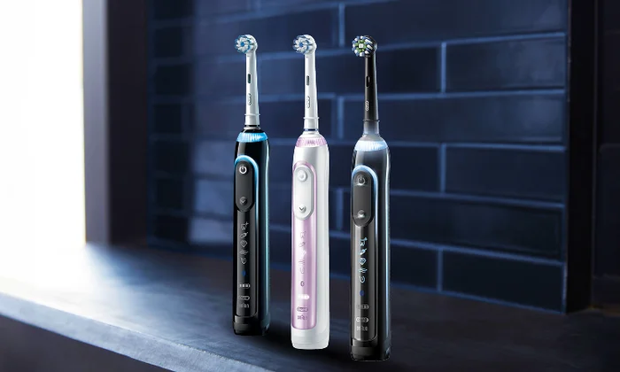 Drei Oral-B Genius Zahnbürsten in Schwarz, Weiß und Lila mit leuchtenden Displays